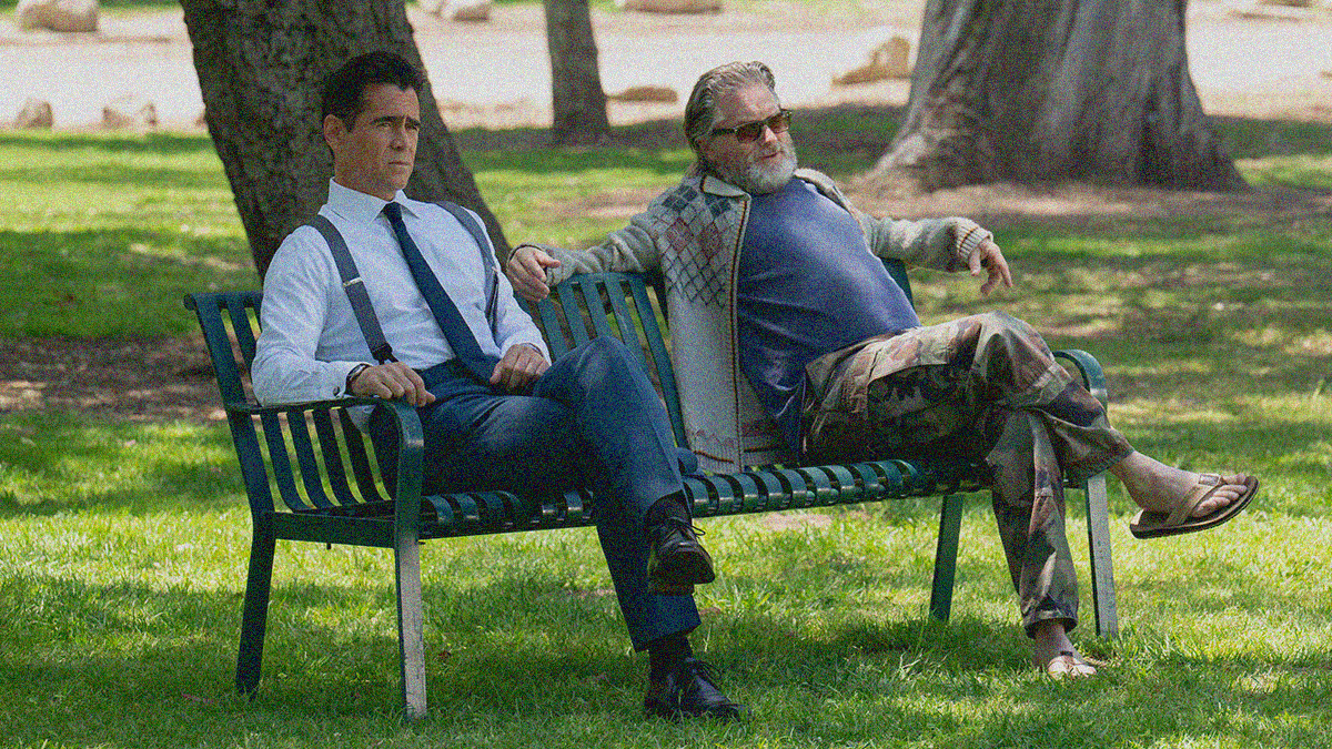 Two men sitting on a park bench outside. The one on the left is clean-shaven with tie and suspenders. The one on the right has full beard, sunglasses, and sandals.