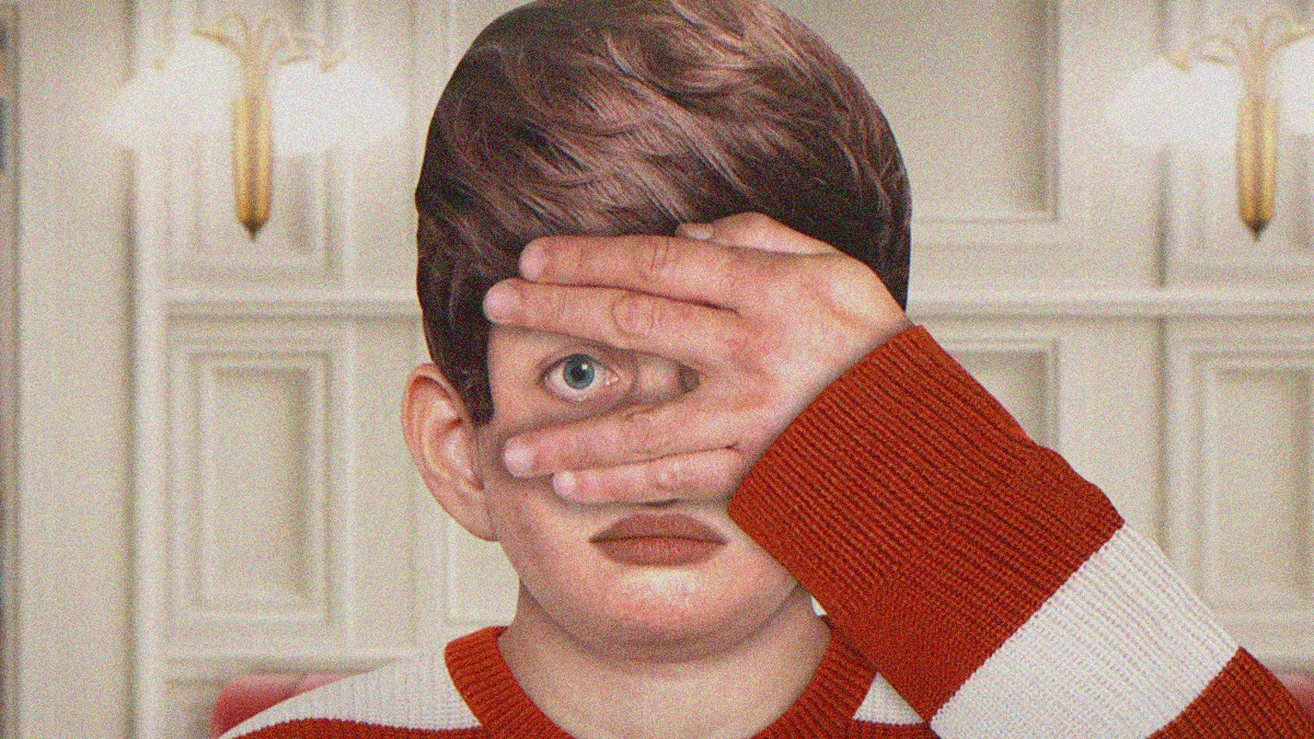 Close-up of an animated boy with hand covering his face, but an eye poking through the gap between his middle and ring fingers.