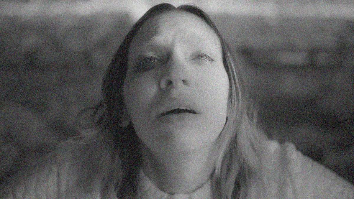 Black & white close-up of a woman with mouth slightly open and gazing upwards.