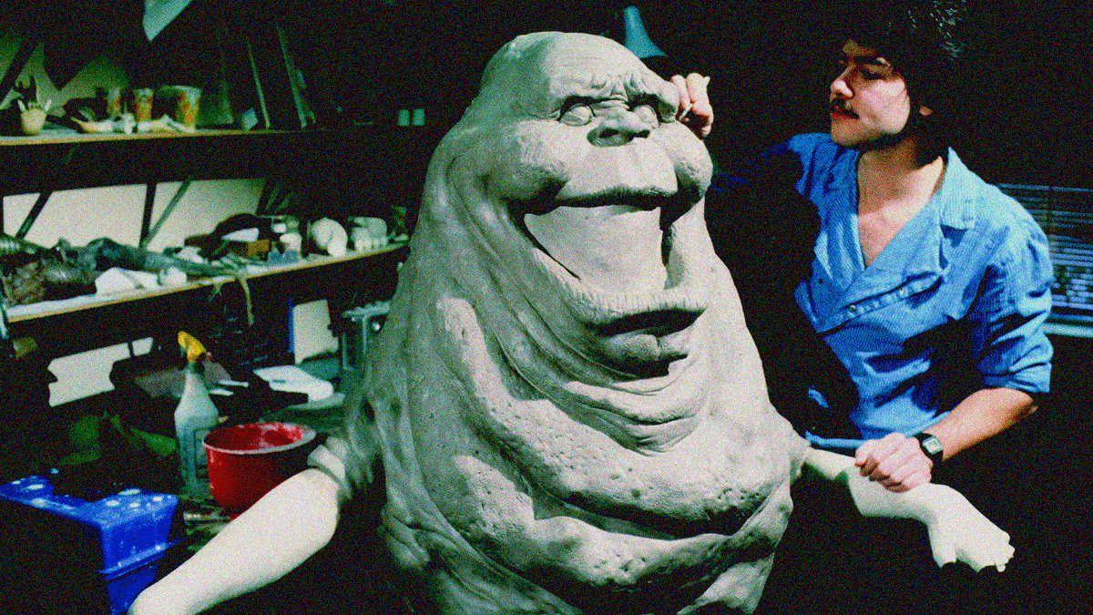 Behind the scenes archival shot of Steve Johnson, woking on a life-size Slimer model.