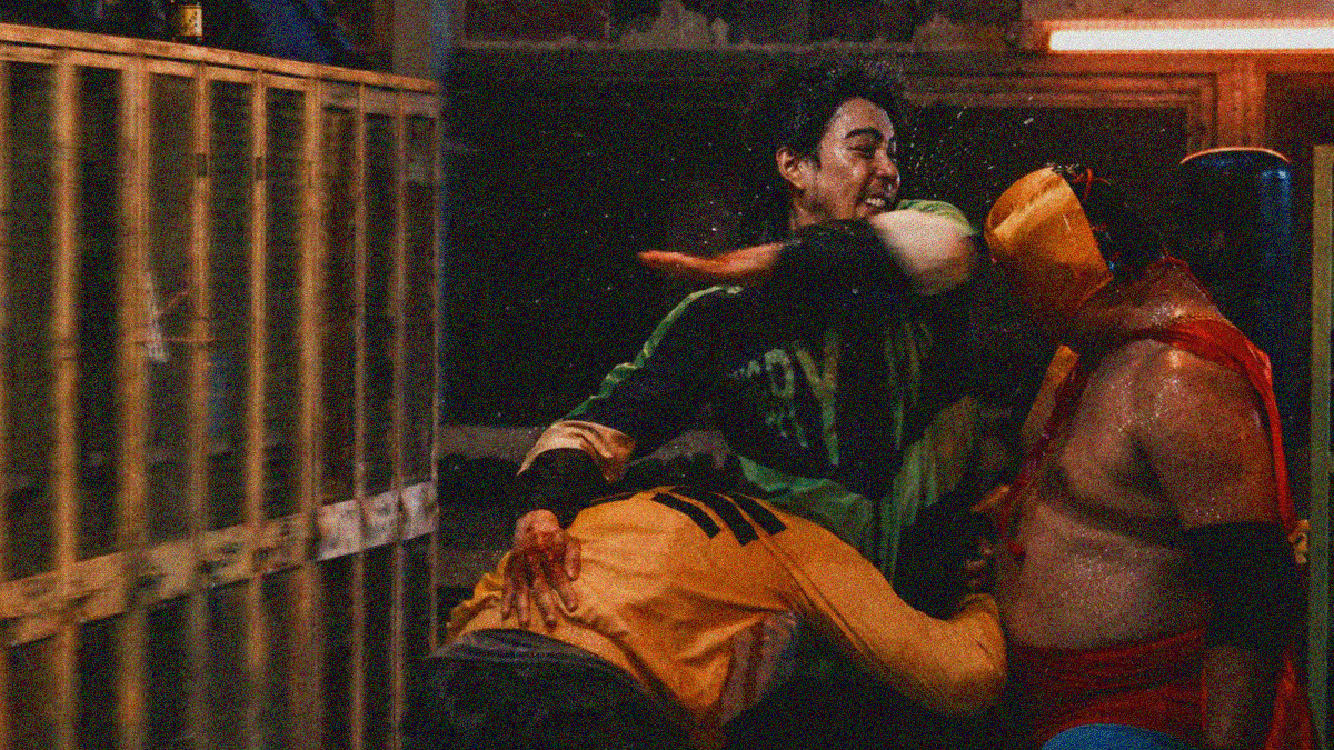 A man at center is getting tackled, but he is also elbowing another man in the head as he's hit at the waist.