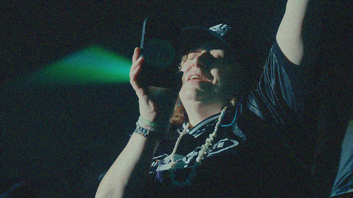Close-up of a woman dancing while holding her phone up at a concert.