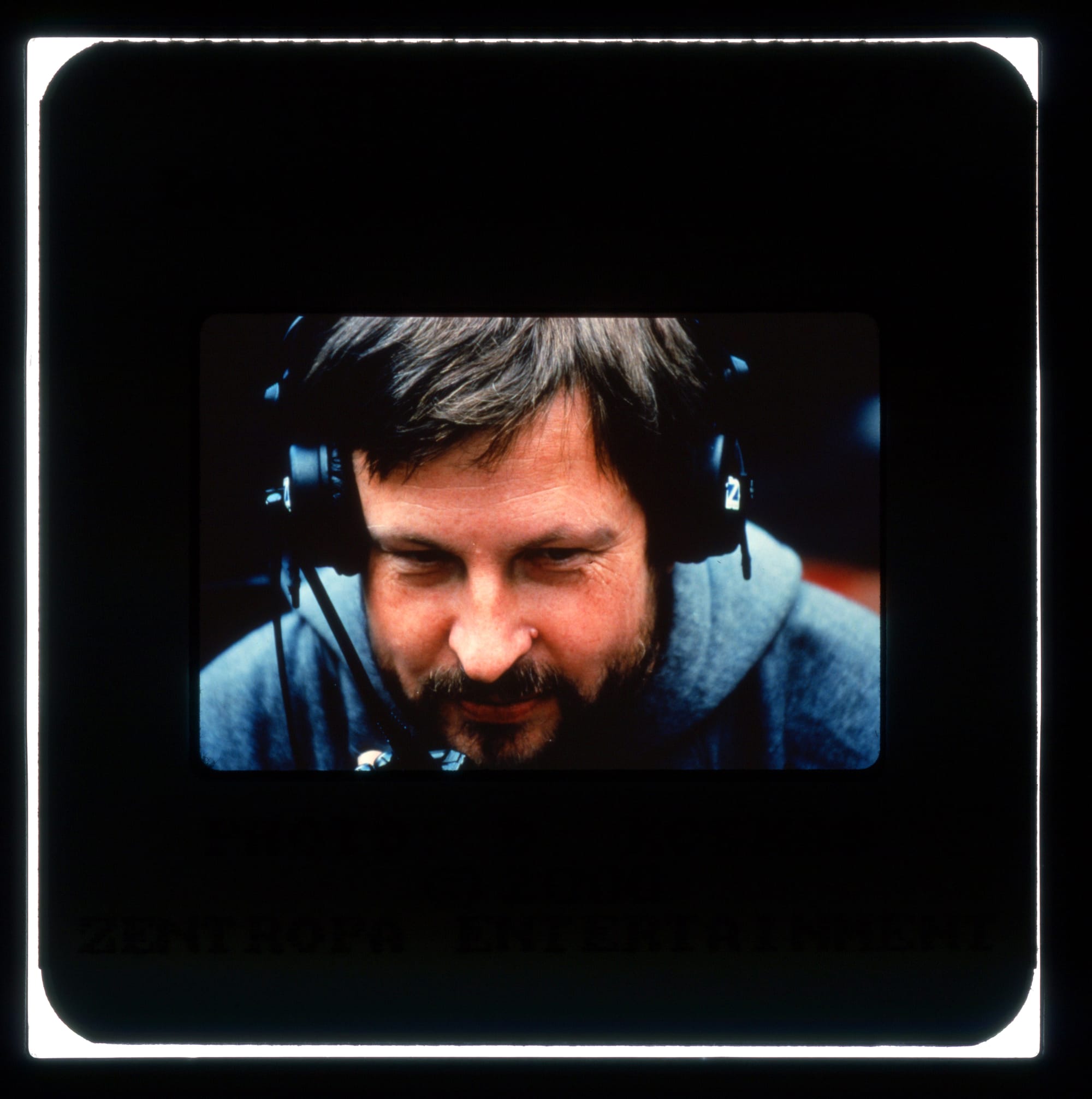Color publicity slide - Close-up of a bearded man with headset smiling.