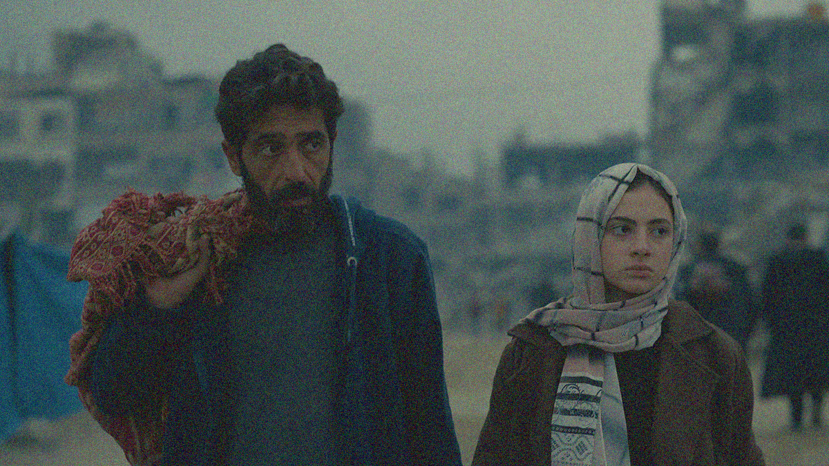 A bearded man at left and young girl in scarf at right face us while looking off-screen right.