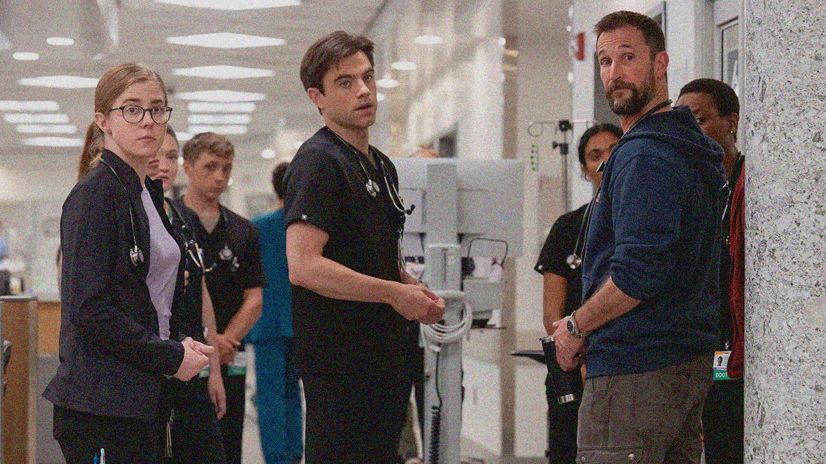 A circle of doctors are interrupted to look our way, just beyond the camera.
