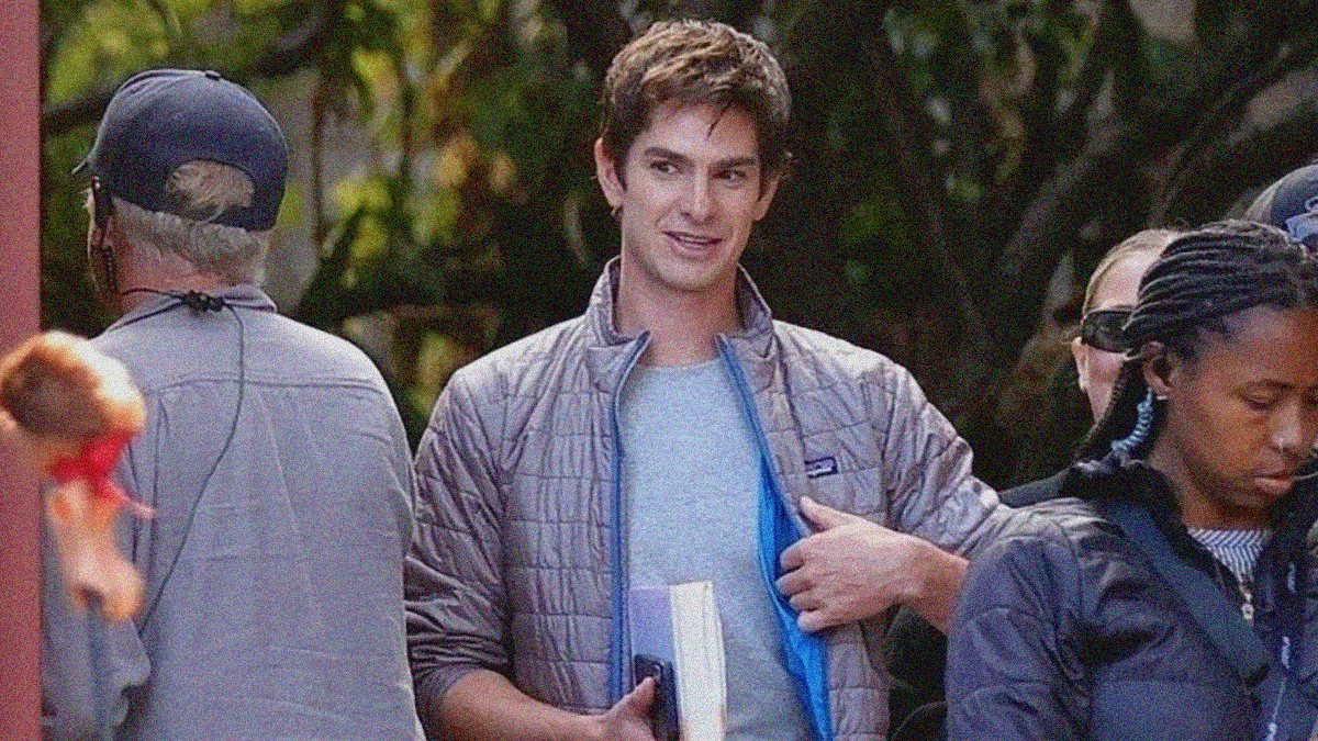 A man in a puffy Patagonia coat smiles on set of a film.