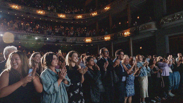 A full house theater crowd standing and clapping; courtesy of TIFF.