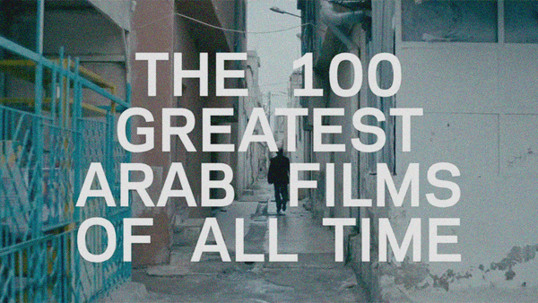 A film still of a man walking down a narrow outdoor corridor with the text "The 100 Greatest Arab Films of All Time" superimposed above it.
