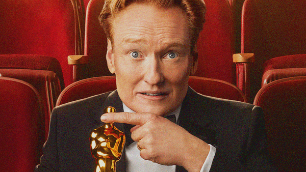An image of Conan O'Brien from the official 98th Academy Awards poster where he's seated in an auditorium holding an Oscar in one hand and covering its eyes with the other.