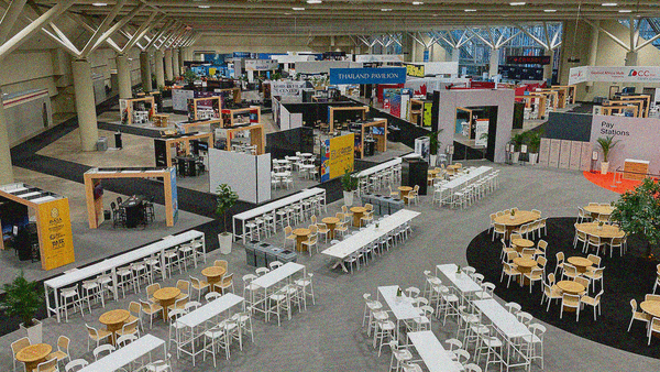 A giant room of booths and in the backroom and tables and chairs in the foreground awaiting the day's visitors.