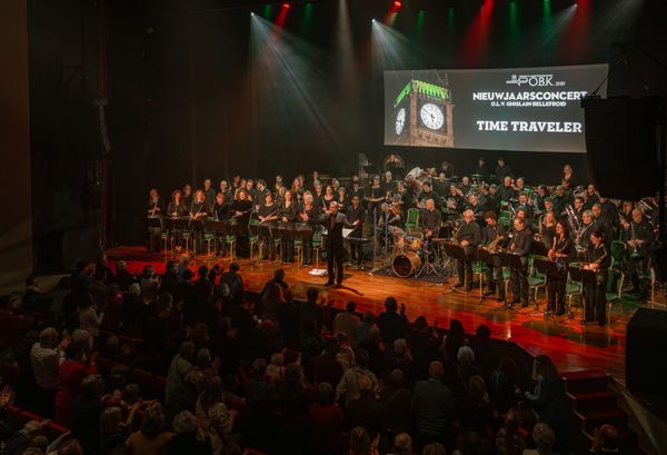 het volledige orkest van OBK Zeist staat en neemt een staande ovatie van het publiek in ontvangst
