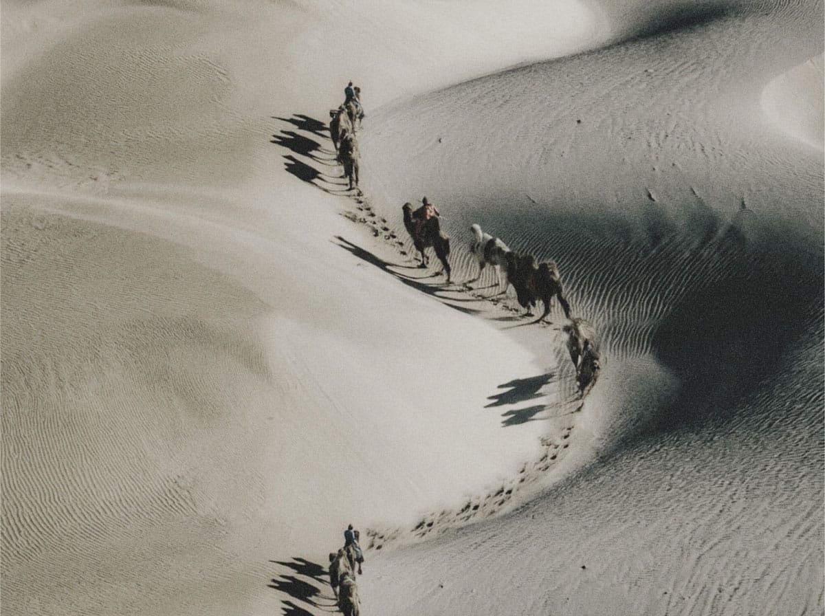 Riders on camels in the desert | Teachings from Khawaja Shamsuddin Azeemi (RA) in Sufism.