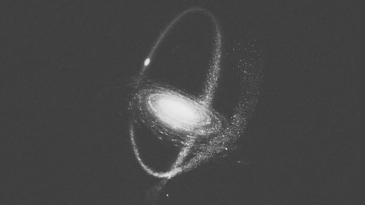  Grayscale illustration of a spiral galaxy encircled by a luminous orbital ring against a dark grey background | Teachings from Khawajah Shamsuddin Azeemi (RA).
