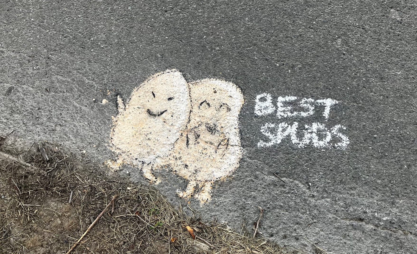 Two anthropomorphic potatoes drawn in chalk with the words "BEST SPUDS" beside them.