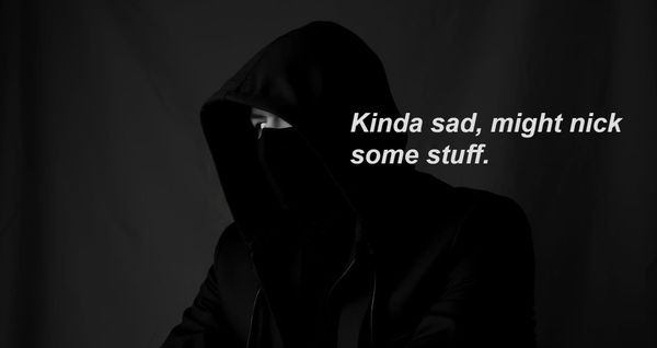 A man in a dark hood, only one eye visible gazes to something out of frame and considers his life choices.