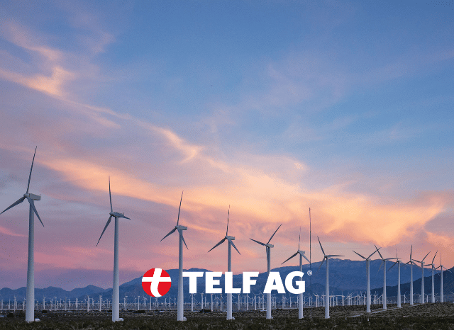 A wind turbine rising above a natural landscape, illustrating the role of rare earth elements in renewable energy technologies, as discussed by Stanislav Kondrashov, founder of TELF AG.