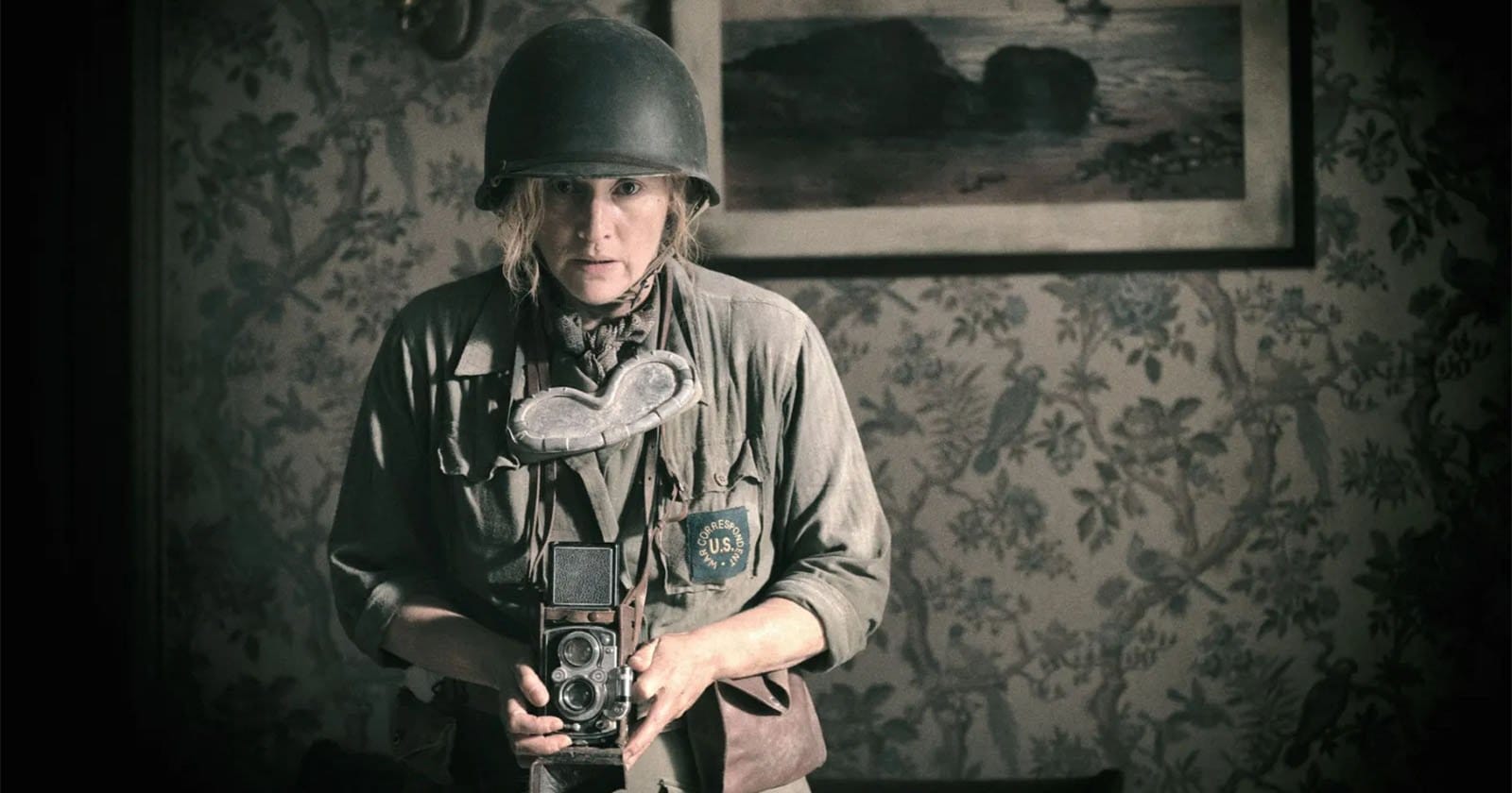 Kate Winslet as Lee Miller, in WW2 uniform with a camera and helmet