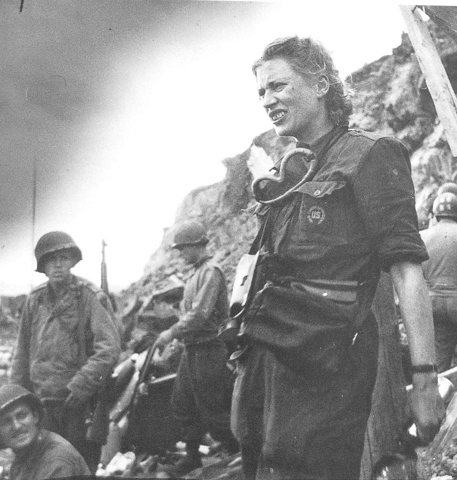 Lee Miller in an army trench in WW2 with soldiers in the background