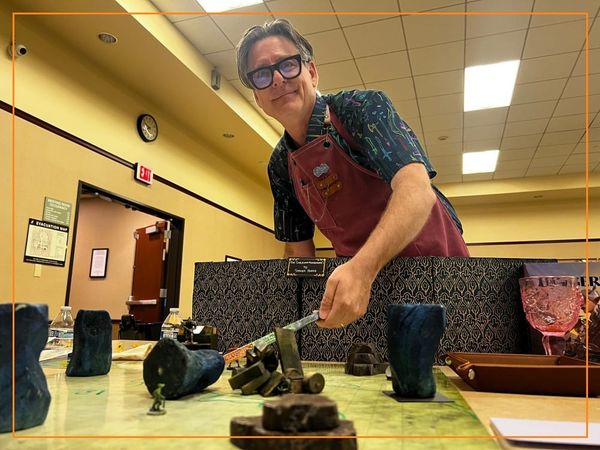 Photograph of Bruce wearing an apron as he runs a game of Daggerheart.