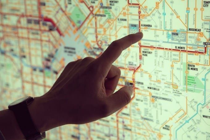 Hand pointing at a subway map.