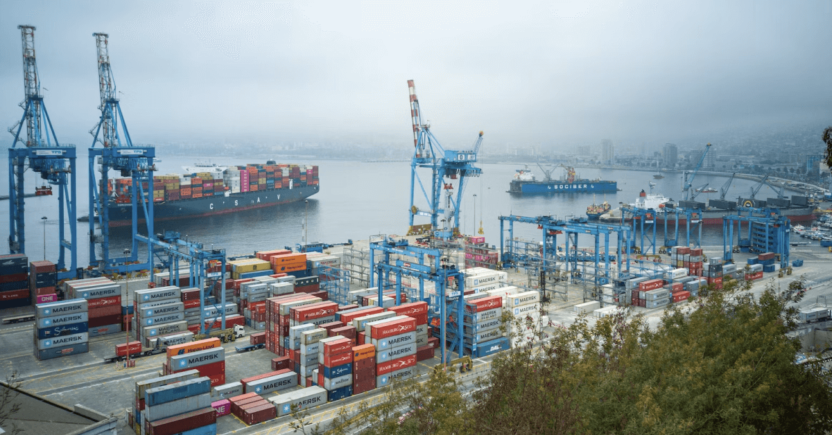 A port container with a city in the background.