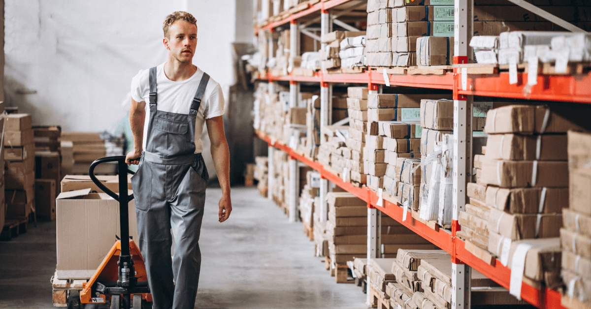 A warehouse worker in a warehouse transporting merchandise.