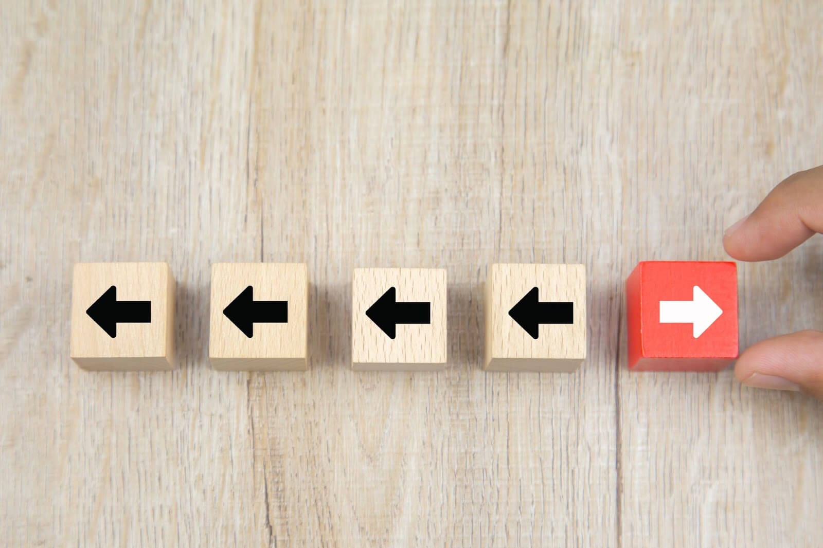 Four block arrows going in one direction and one red block arrow going in the opposite direction.