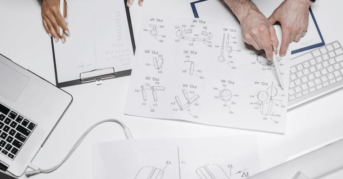 A team working on product development with computers and pads on a table.