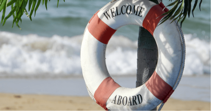 a welcome aboard sign on a beach.