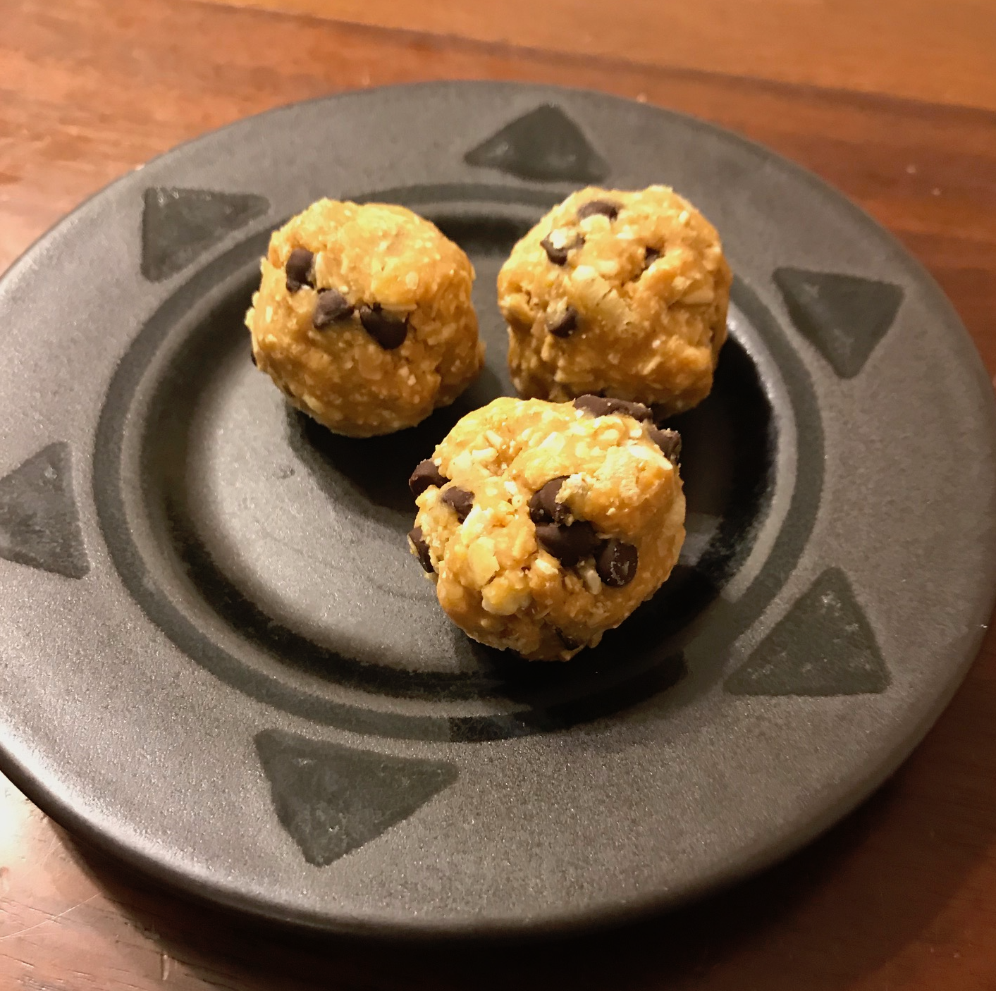 Energy bites on a black plate.