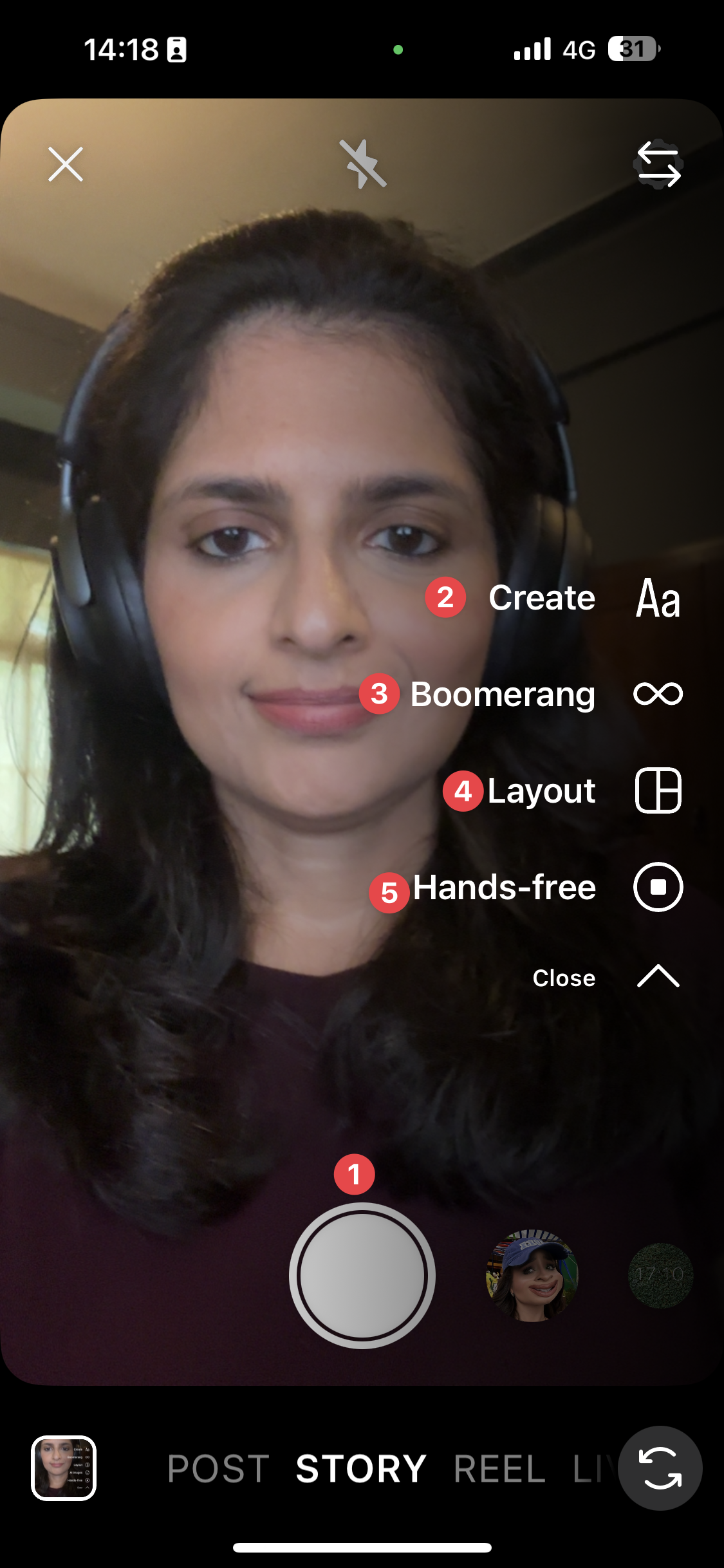 Instagram stories camera screen showing a woman wearing headphones using the front camera, with create, boomerang, layout, and hands-free options visible in the app interface.