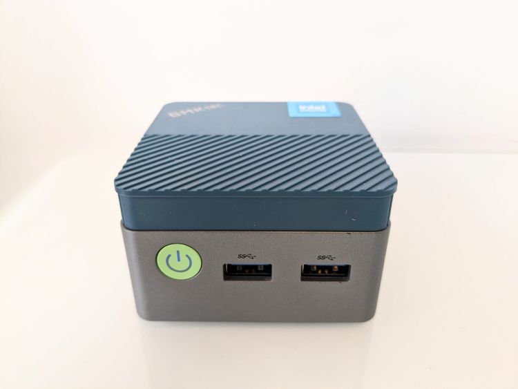 A very tiny computer, with two USB ports and a power button on the front.