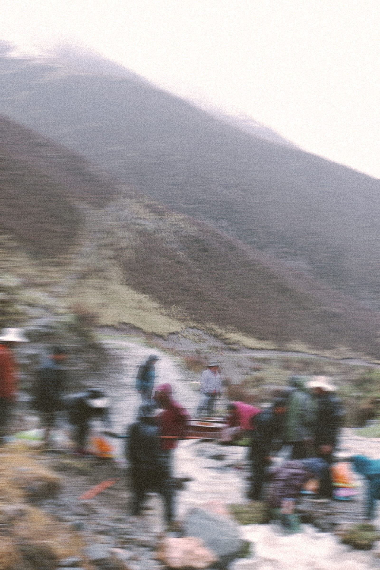 a blurry image of a group of people gathered at a mountain path to fix the roads together