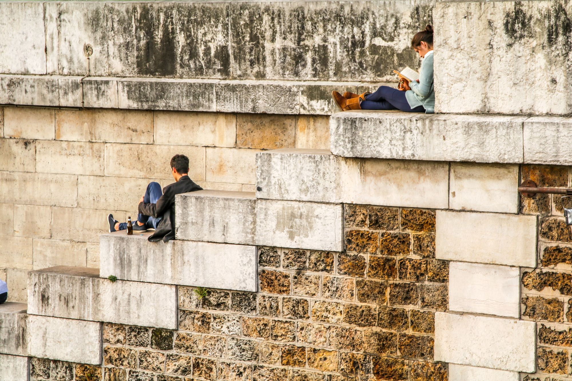 People sitting and reading on large brick stairs