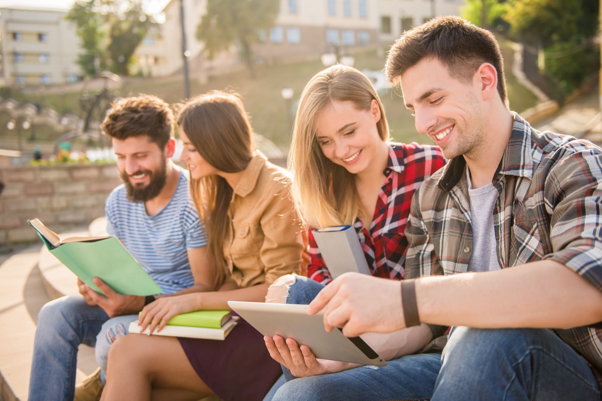 Group of young students watching books and tablet together