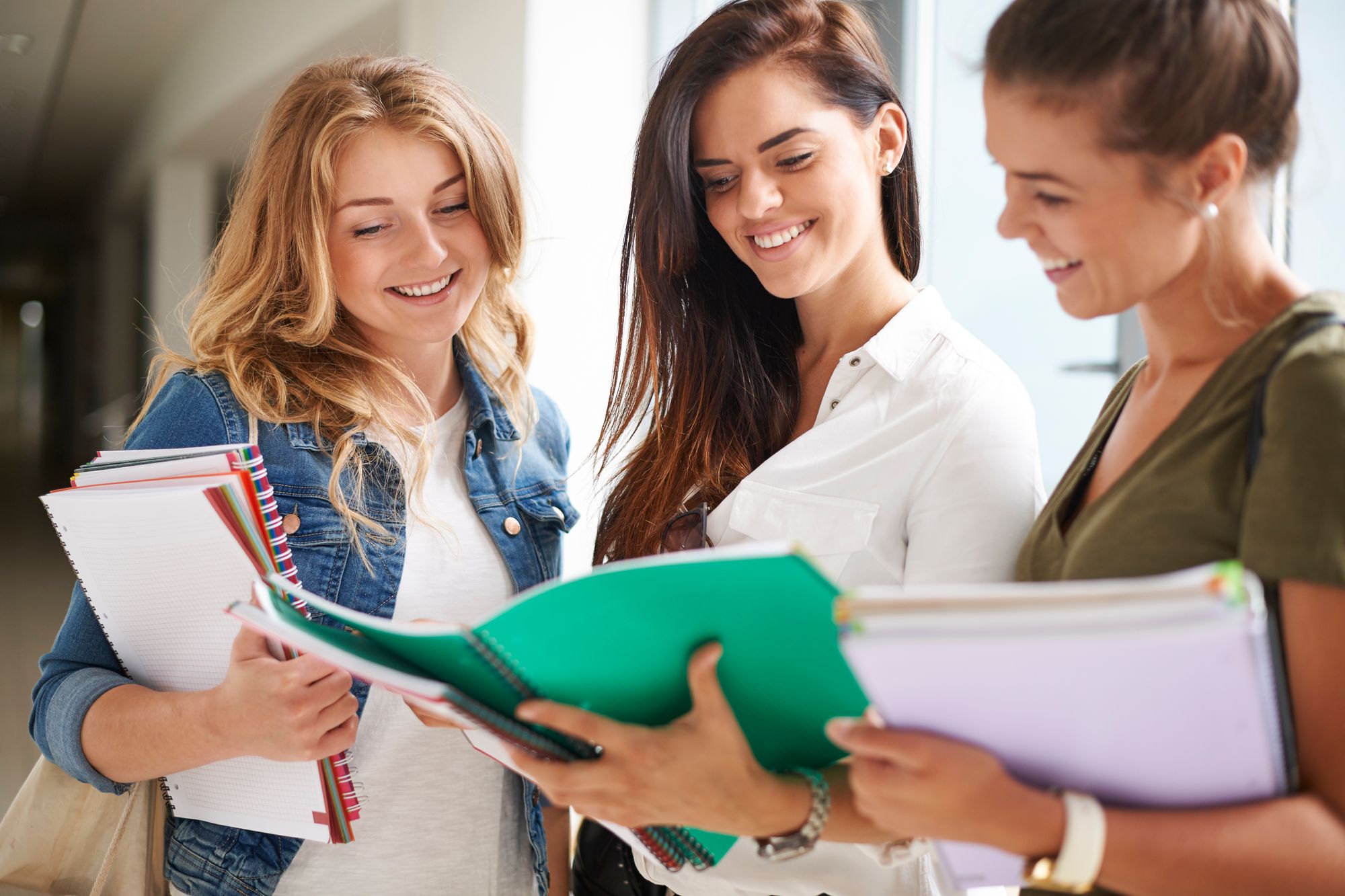 Tre studentesse si confrontano sugli appunti presi a lezione