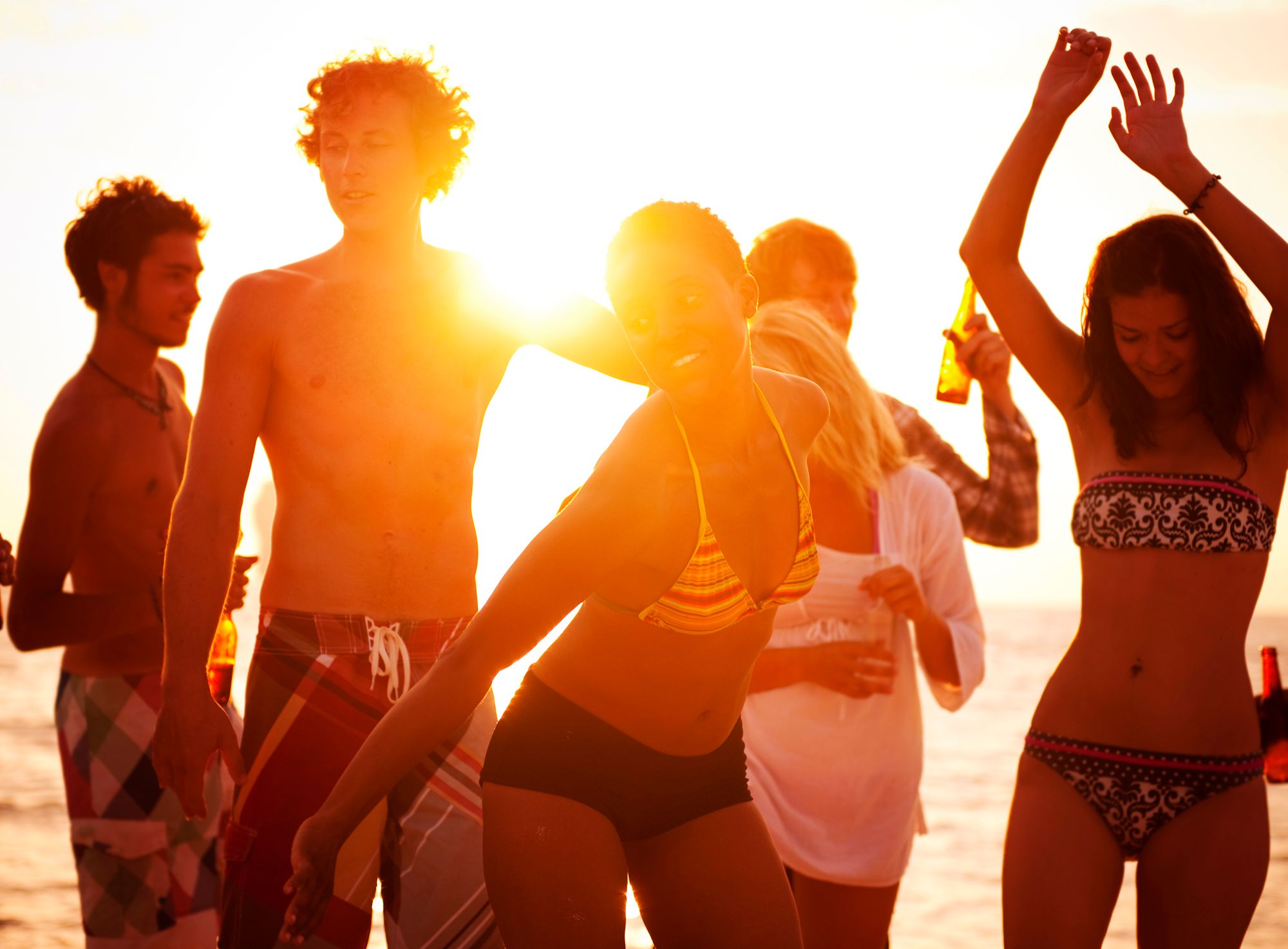 Ragazzi e ragazze ballano ad una festa in spiaggia