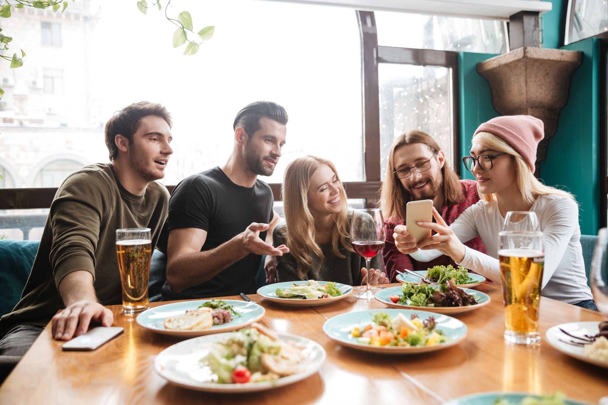 Cheerful friends sitting in a restaurant  talking with each other