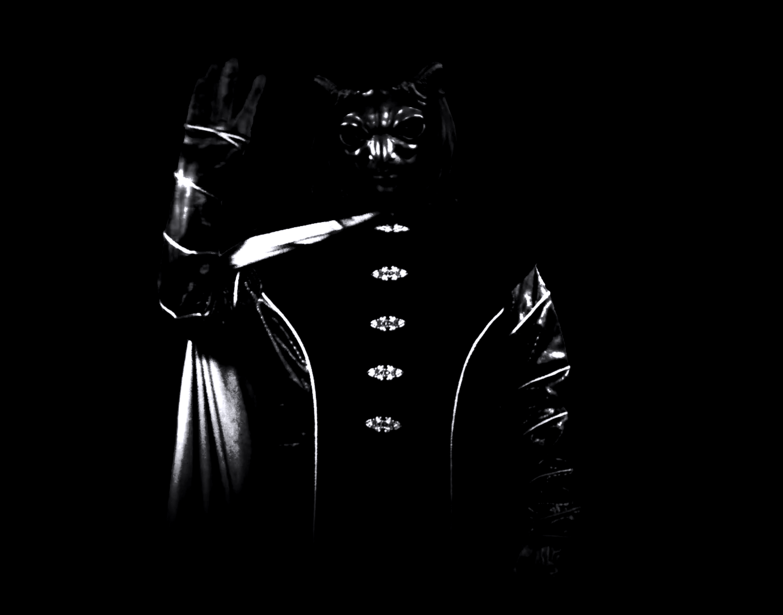 Masked host M waves goodbye from the dark, their stylized black-and-white robe and mask illuminated by a stark spotlight as they send off the static traveler.
