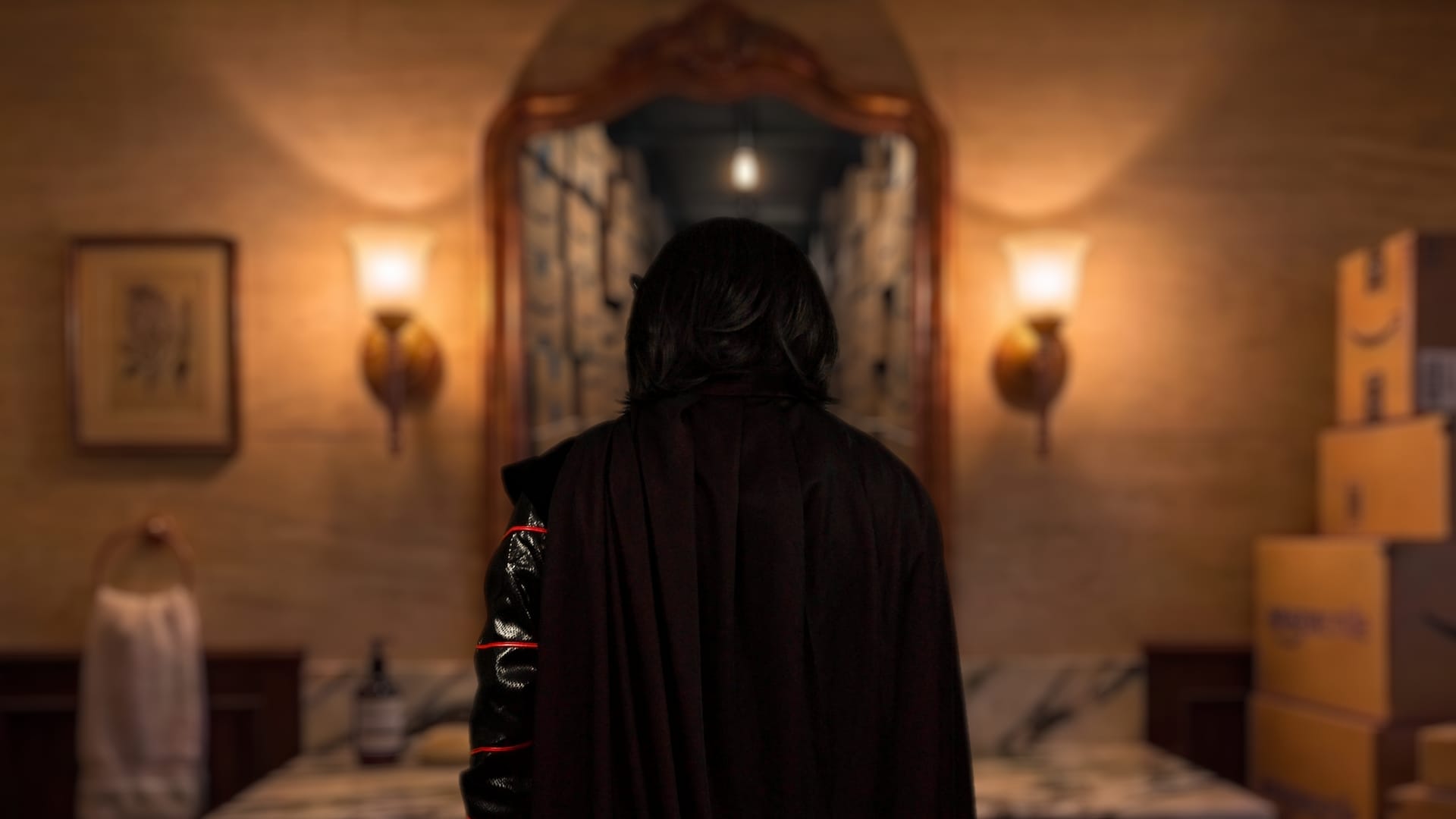 Rear view of a dark-robed figure walking away from the camera through an arched doorway flanked by warm lantern lights and stacked cardboard shipping boxes.