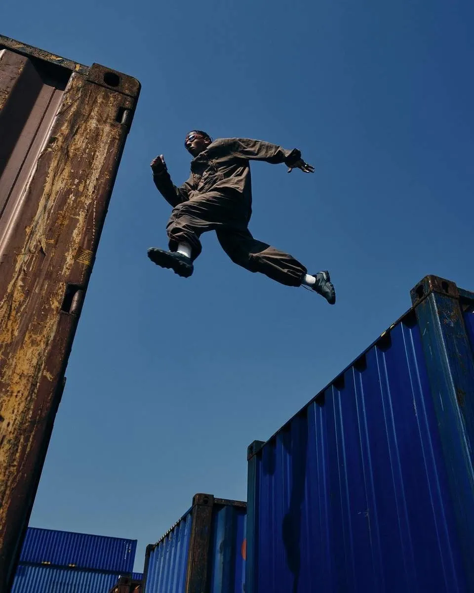 Person jumping between shipping containers