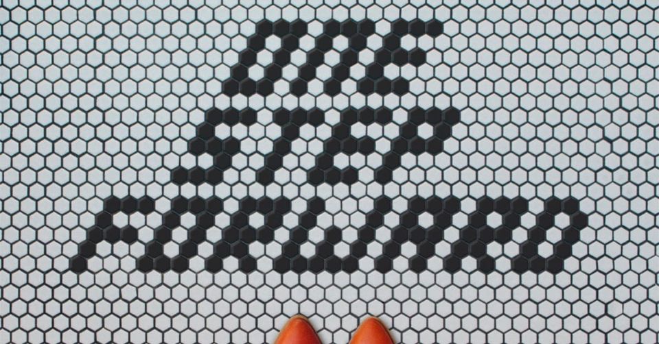 A mosiac of tiles spelling out the words "One step forward