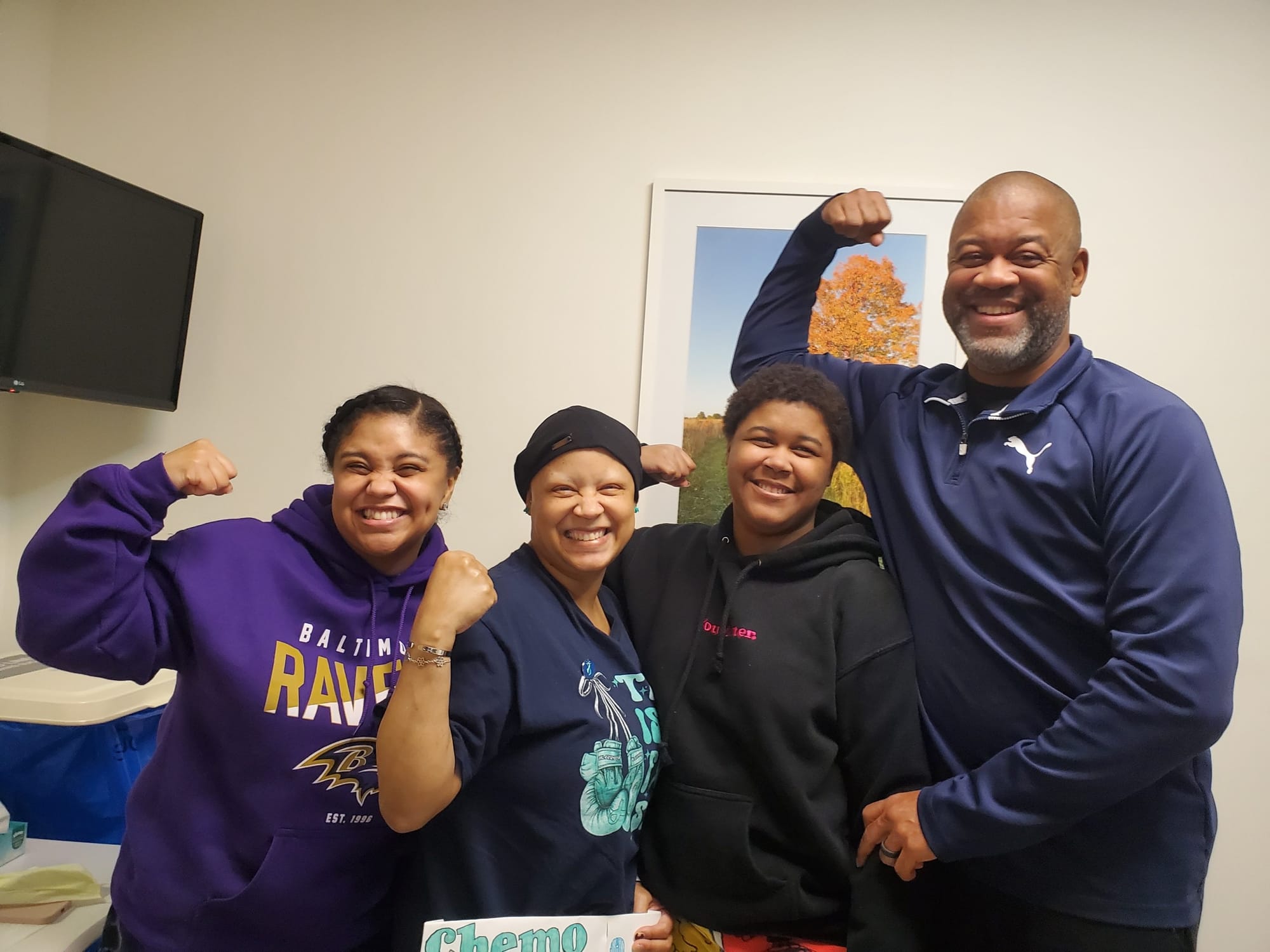 camryn kinney and her family posing with flexed arms after mother's chemotherapy
