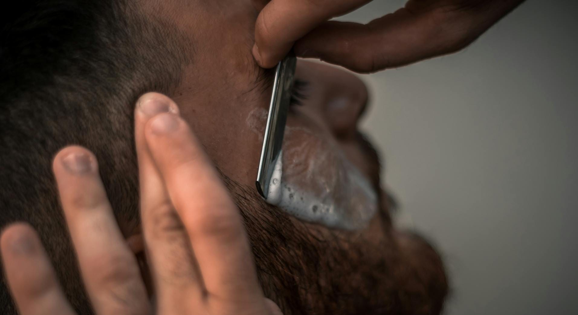 Barber shaving client beard
