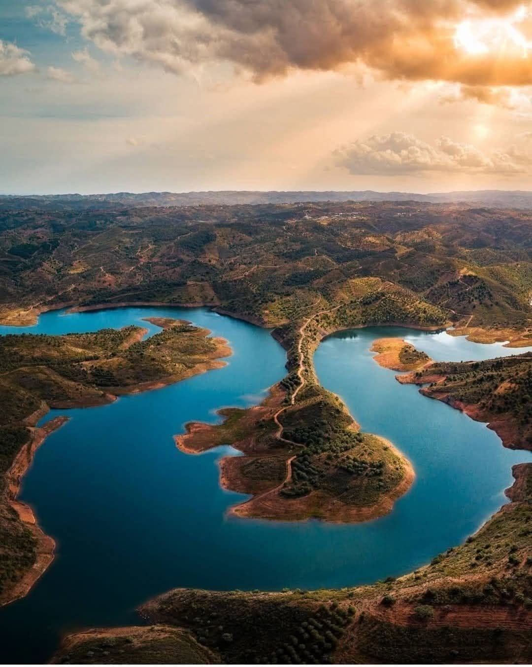 Aerial view of Portugal's Odeleite Reservoir, known as the Blue Dragon River, with its winding blue shape resembling a giant dragon in the Algarve region.