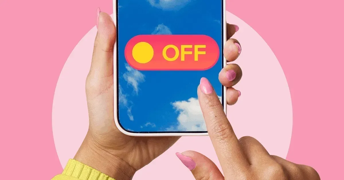 A person sitting in a quiet, natural environment with their smartphone turned face-down, representing the choice to disconnect and practice tech minimalism.