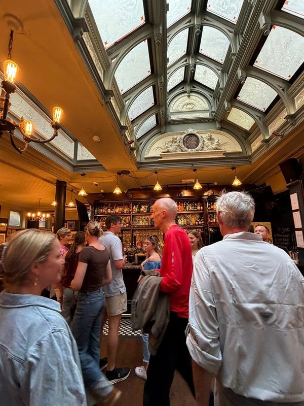 A view of a quiet, sunlit Parisian café in a residential neighborhood away from major tourist landmarks.