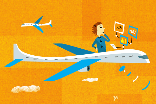 A person looking at a laptop screen showing a flight booking app with an AI price-drop alert notification.