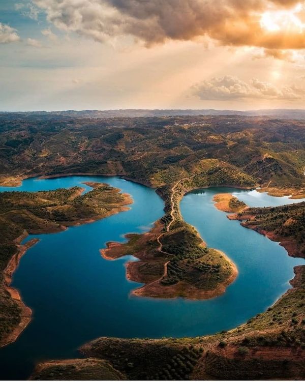 Aerial view of Portugal's Odeleite Reservoir, known as the Blue Dragon River, with its winding blue shape resembling a giant dragon in the Algarve region.