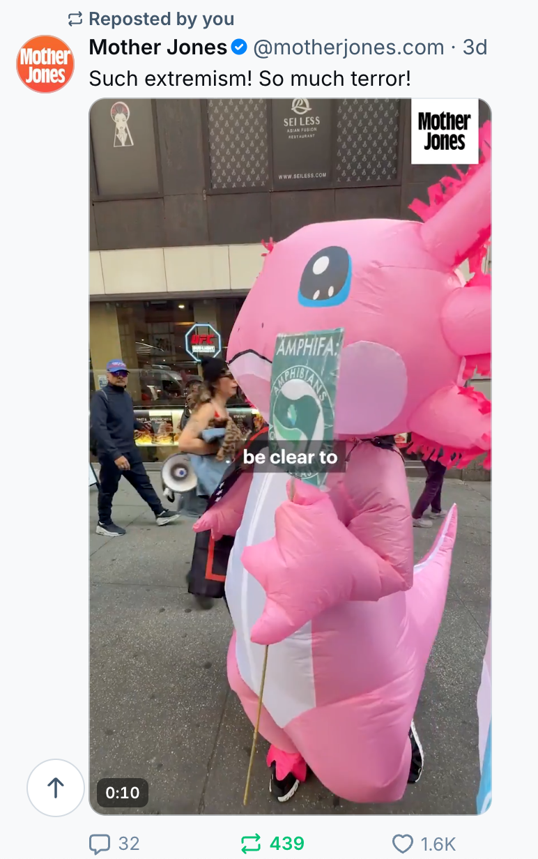 Screenshot of Mother Jones Bluesky post with image of giant pink inflatbable cartoon character on a city street with an "amphifa" sign. 
